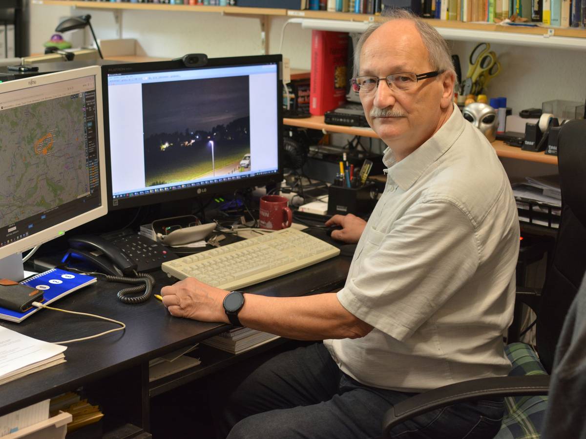 UFO-Forscher Hans-Werner Peiniger sitzt vor zwei Computermonitoren an einem Schreibtisch und wertet Aufnahmen aus.
