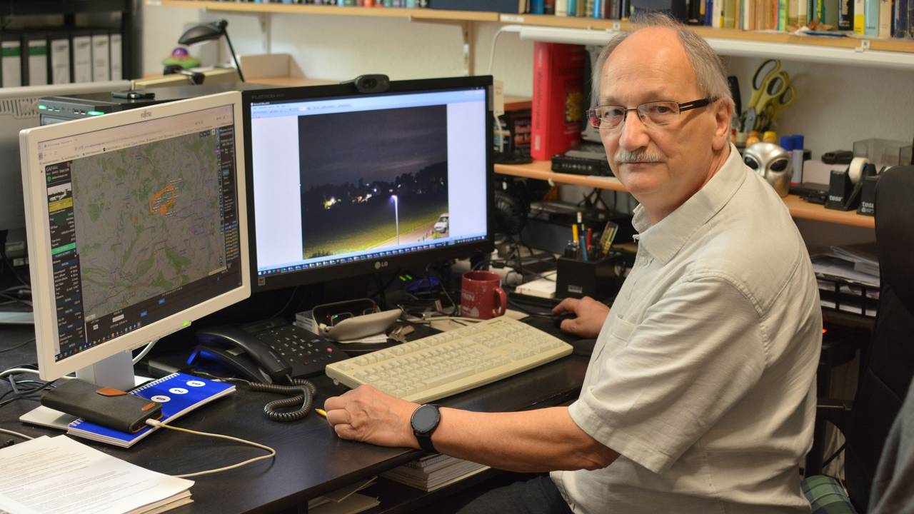 UFO-Forscher Hans-Werner Peiniger sitzt vor zwei Computermonitoren an einem Schreibtisch und wertet Aufnahmen aus.