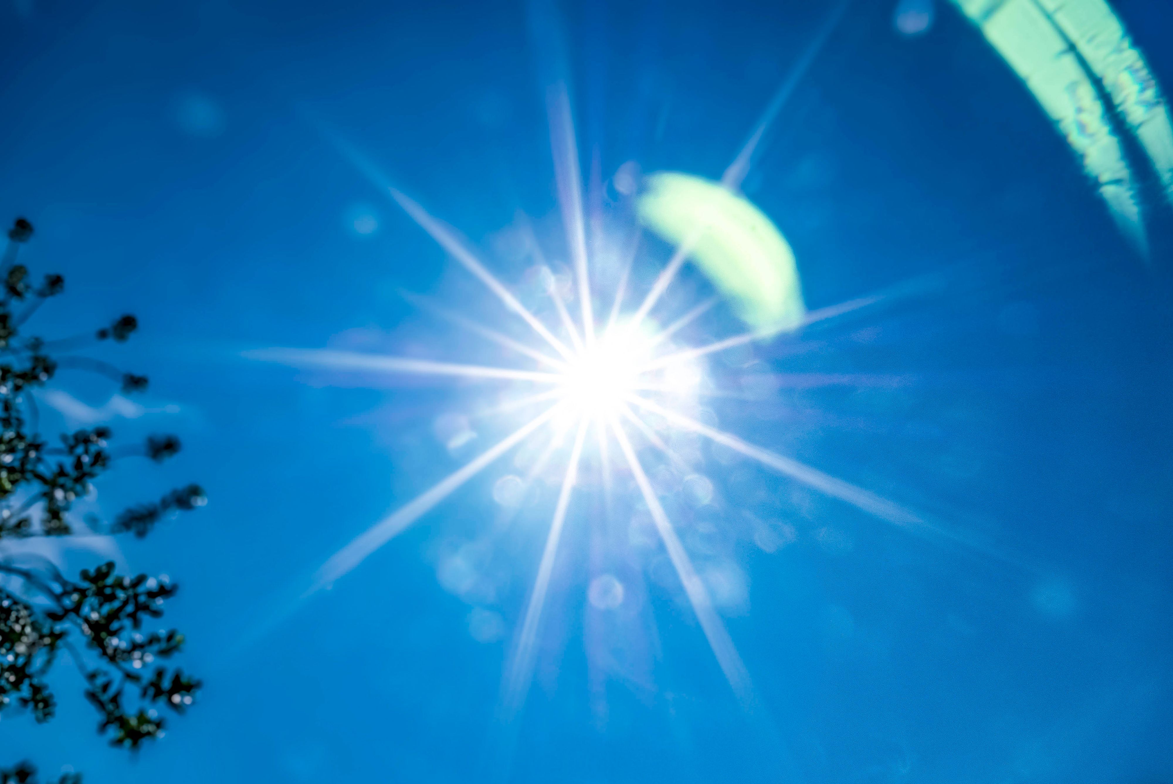 Die Sonne strahlt am blauen Himmel.