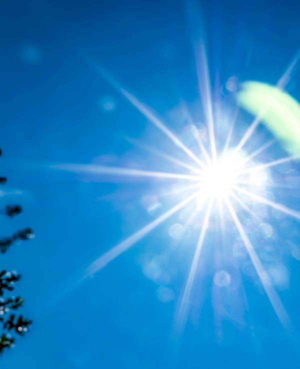 Die Sonne strahlt am blauen Himmel.