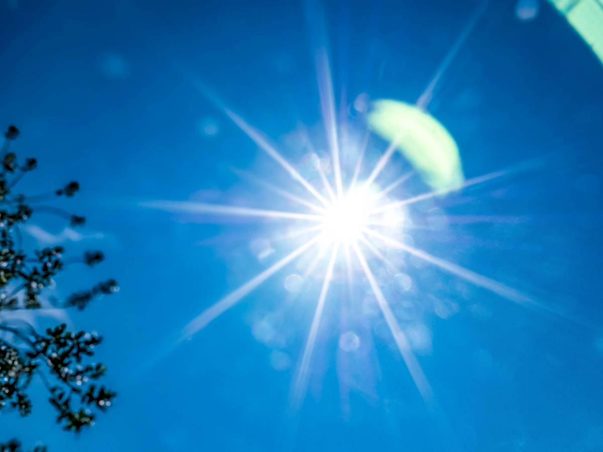 Die Sonne strahlt am blauen Himmel.