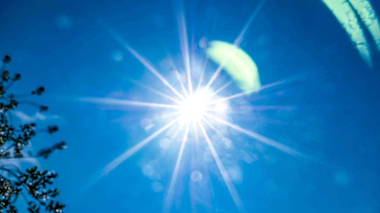 Die Sonne strahlt am blauen Himmel.