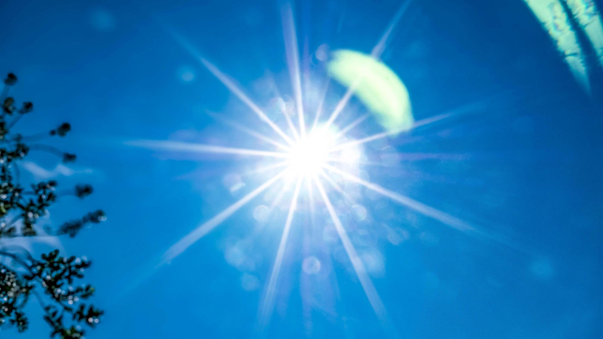 Die Sonne strahlt am blauen Himmel.