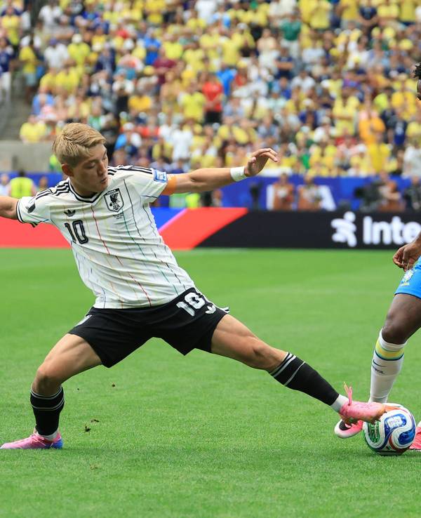 Ritsu Doan versucht, Vini Jr. den Ball vom Fuß zu spitzeln.