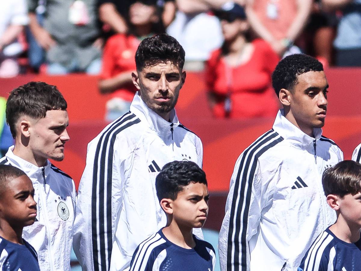 Florian Wirtz, Kai Havertz und Jamal Musiala stehen vor einem Spiel während der Hymne nebeneinander.