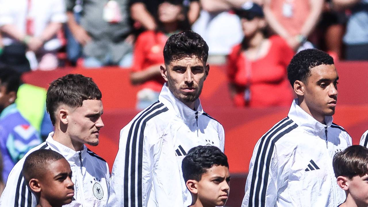 Florian Wirtz, Kai Havertz und Jamal Musiala stehen vor einem Spiel während der Hymne nebeneinander.