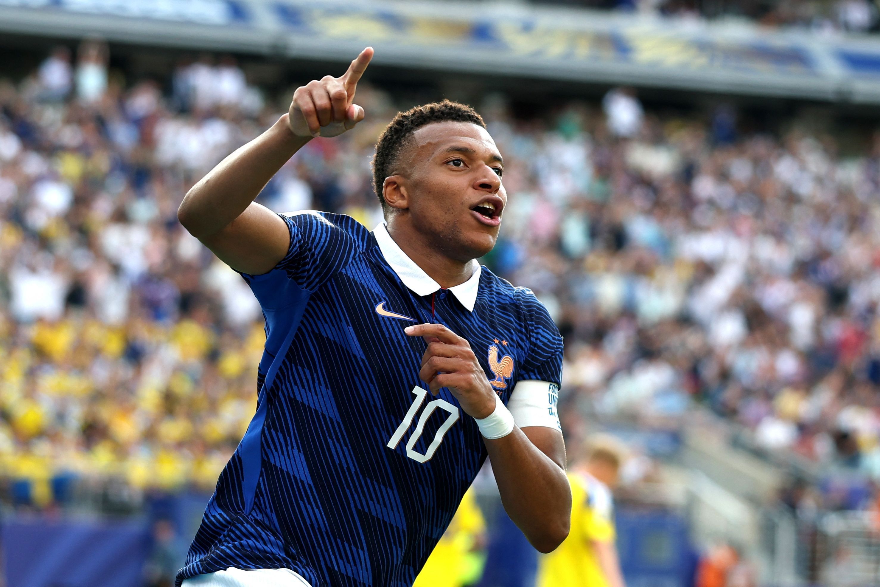 Kylian Mbappé jubelt und zeigt nach oben.