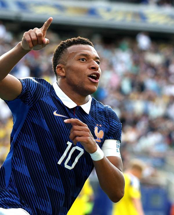Kylian Mbappé jubelt und zeigt nach oben.