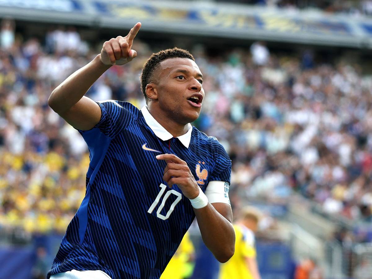Kylian Mbappé jubelt und zeigt nach oben.