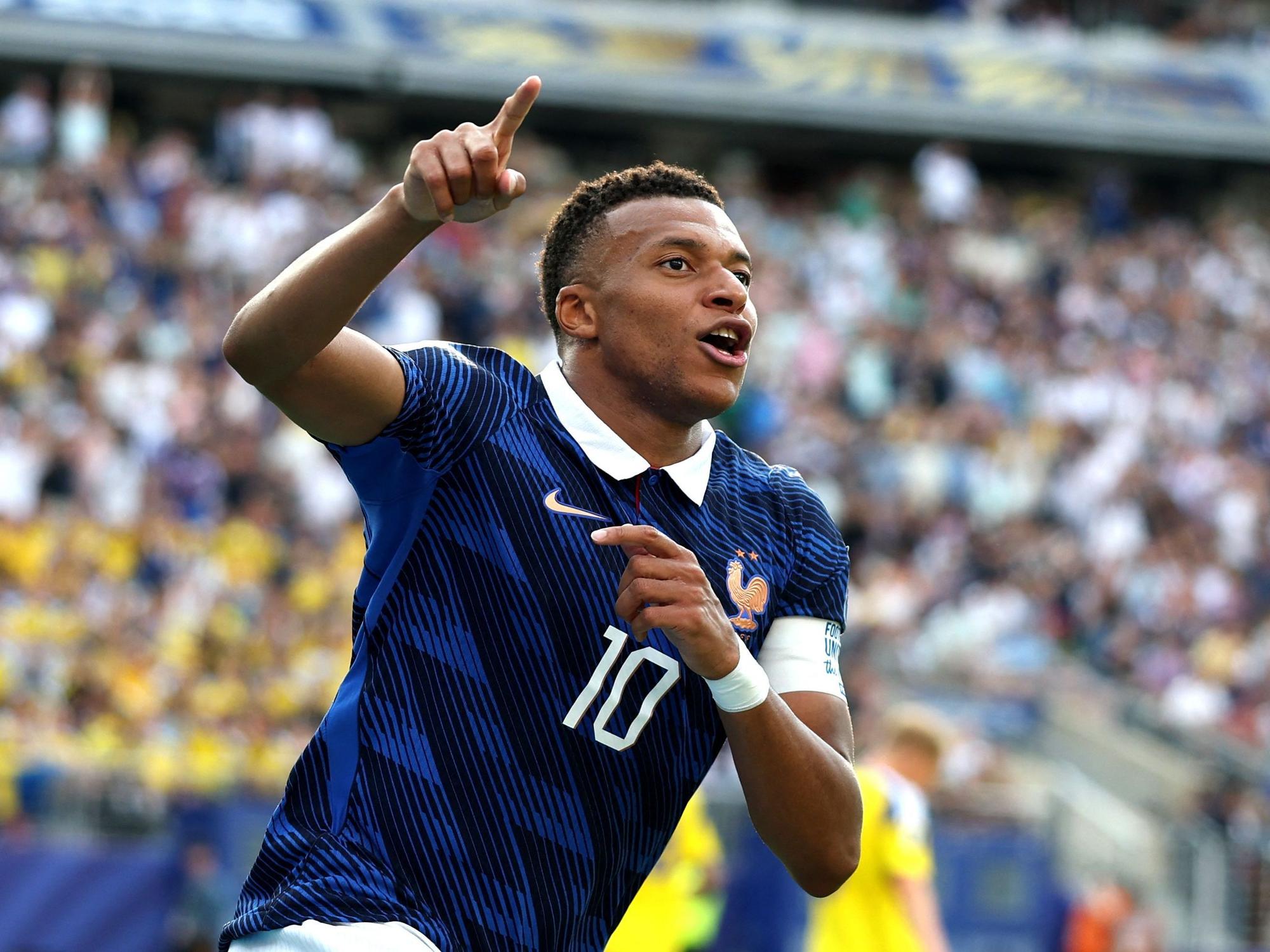 Kylian Mbappé jubelt und zeigt nach oben.