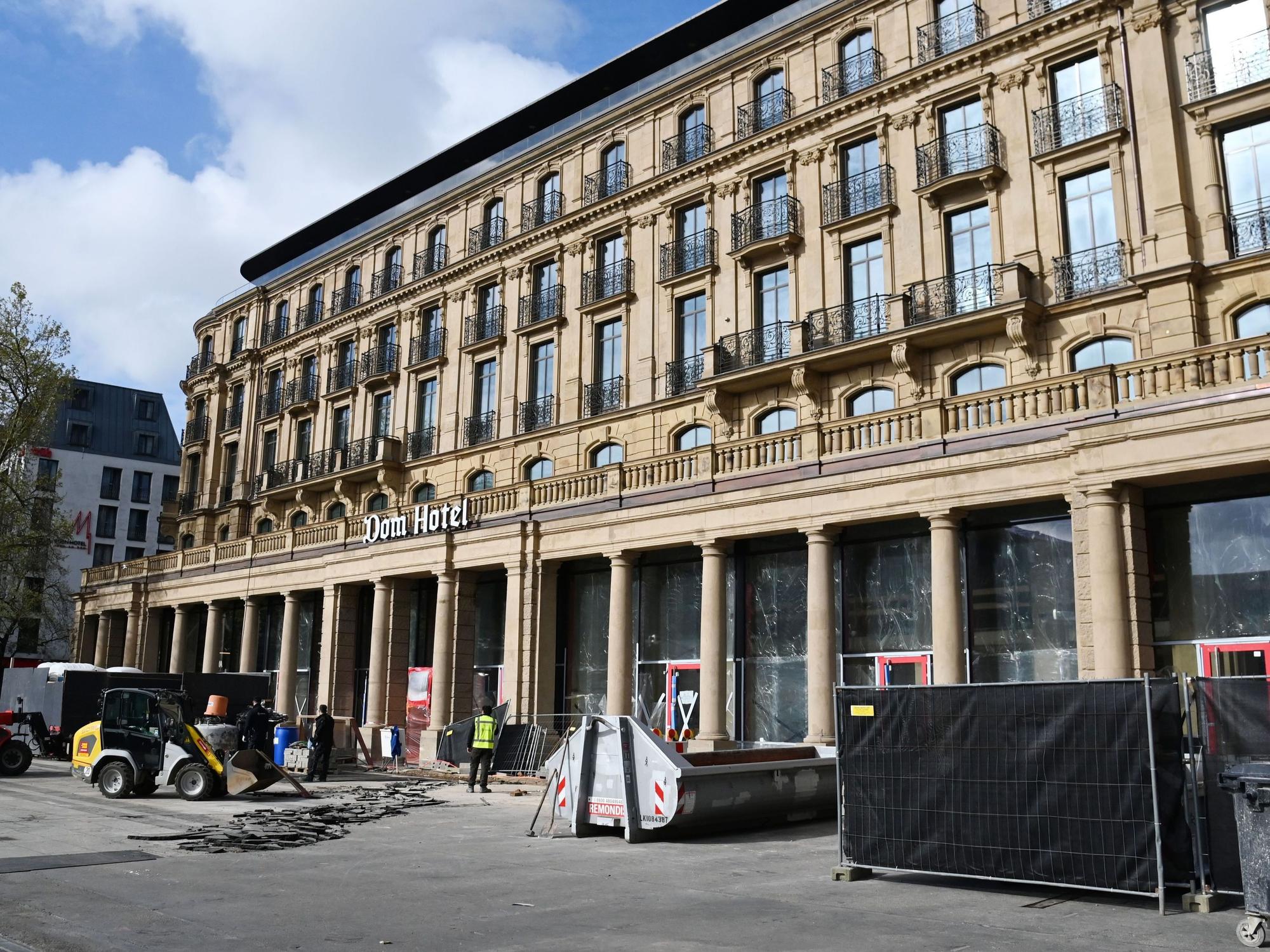 Vor dem Dom-Hotel wird ein Bodenbelag entfernt und der Bauzaun weiter abgebaut.