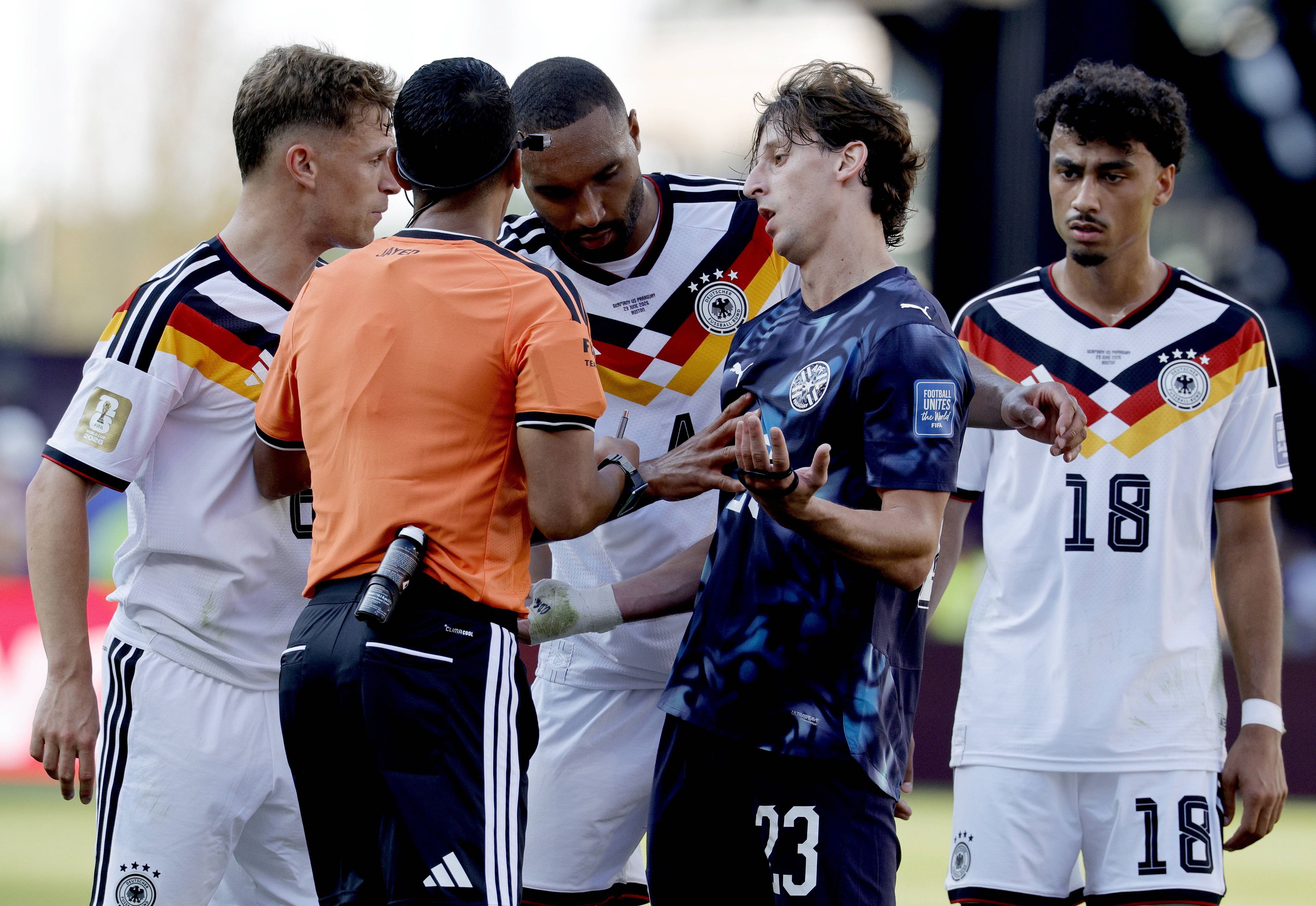 Der Schiedsrichter diskutiert mit Matias Galarza und drei deutschen Spielern.