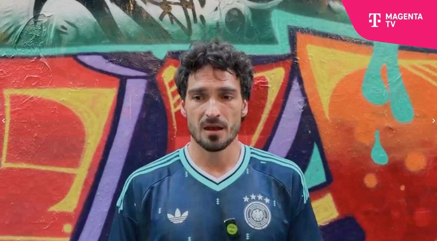 Mats Hummels spricht und steht vor einer bunten Wand.