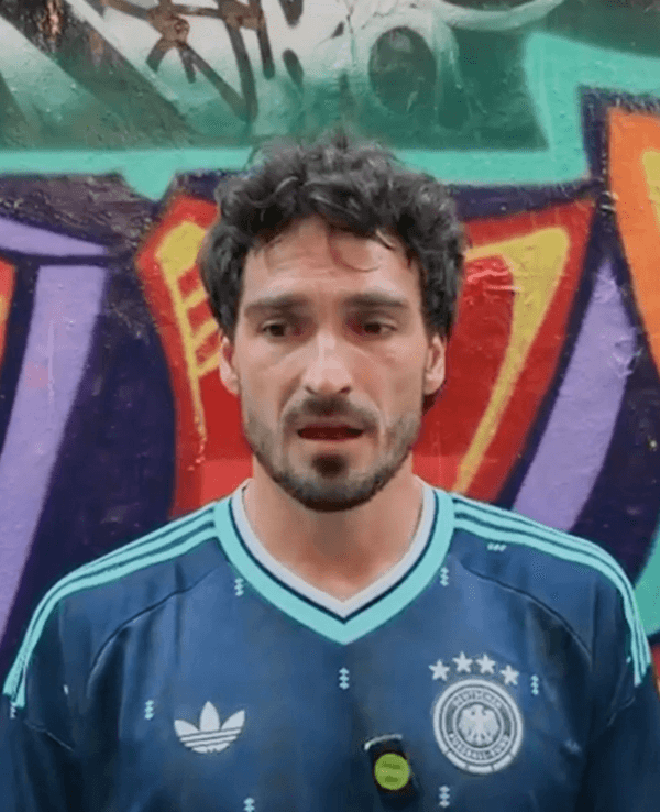 Mats Hummels spricht und steht vor einer bunten Wand.