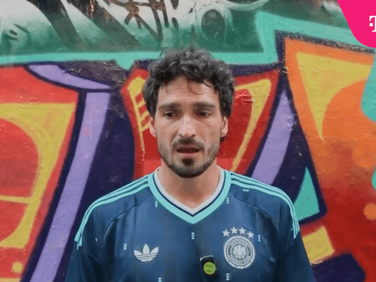Mats Hummels spricht und steht vor einer bunten Wand.
