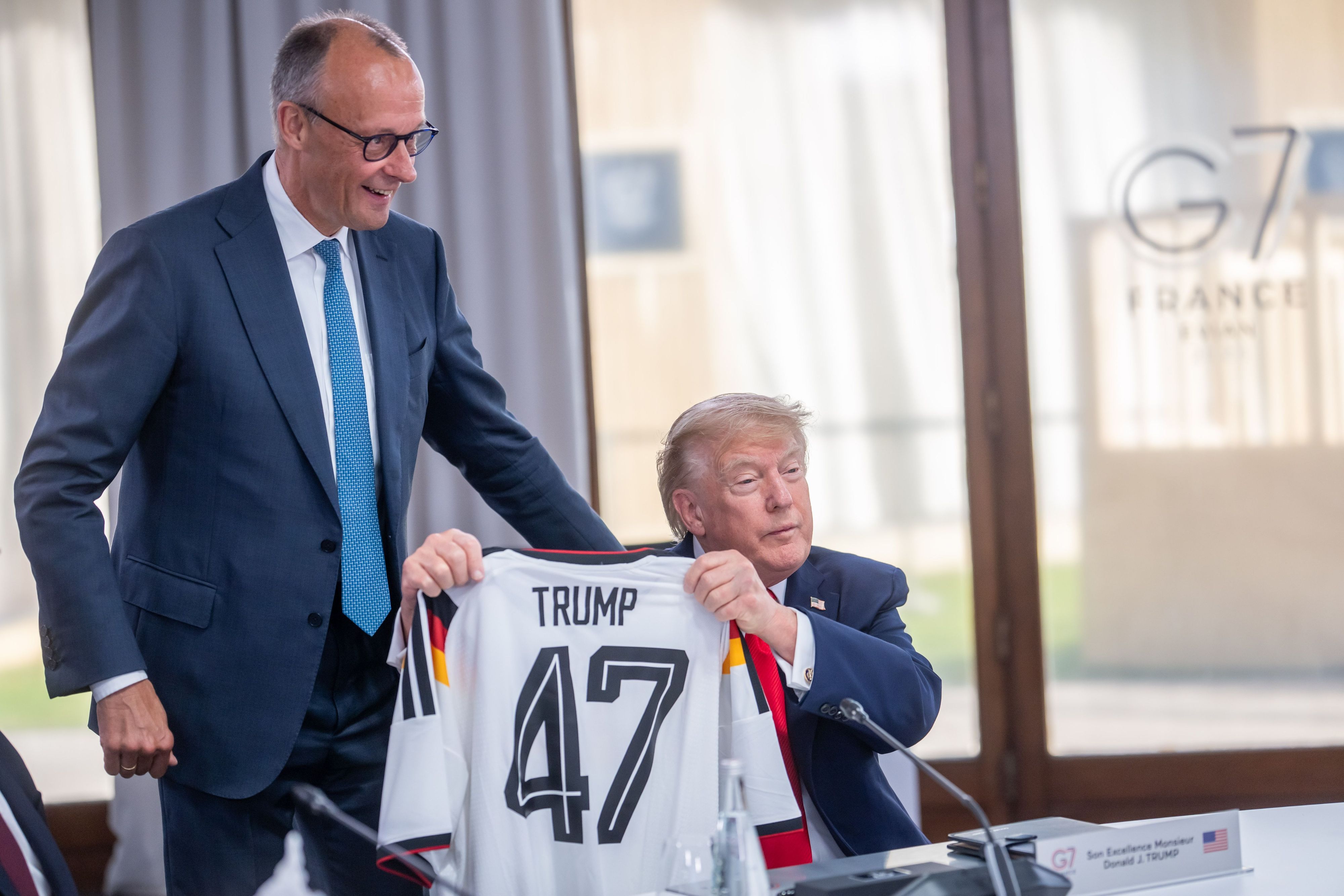 Bundeskanzler Friedrich Merz gibt US-Präsident Donald Trump ein DFB-Trikot.