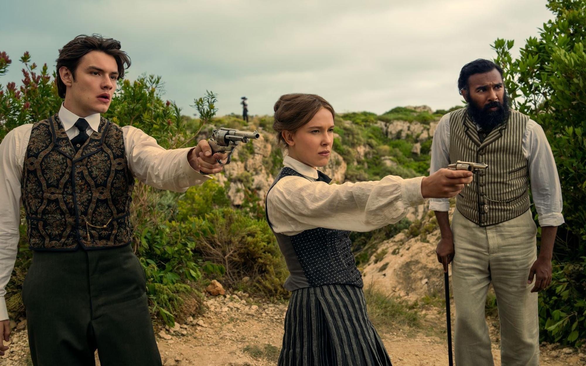 Tewkesbury (Louis Partridge, links), Enola Holmes (Millie Bobby Brown) und Dr. Watson (Himesh Patel) lassen nichts unversucht, um Sherlok zu befreien. (Bild: John Wilson/Netflix 2026)