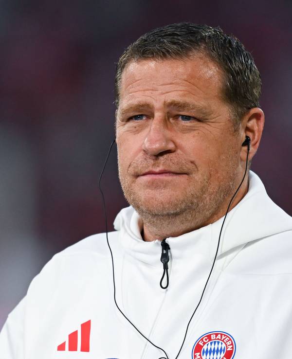 Max Eberl trägt bei einem Interview Kopfhörer im Ohr.