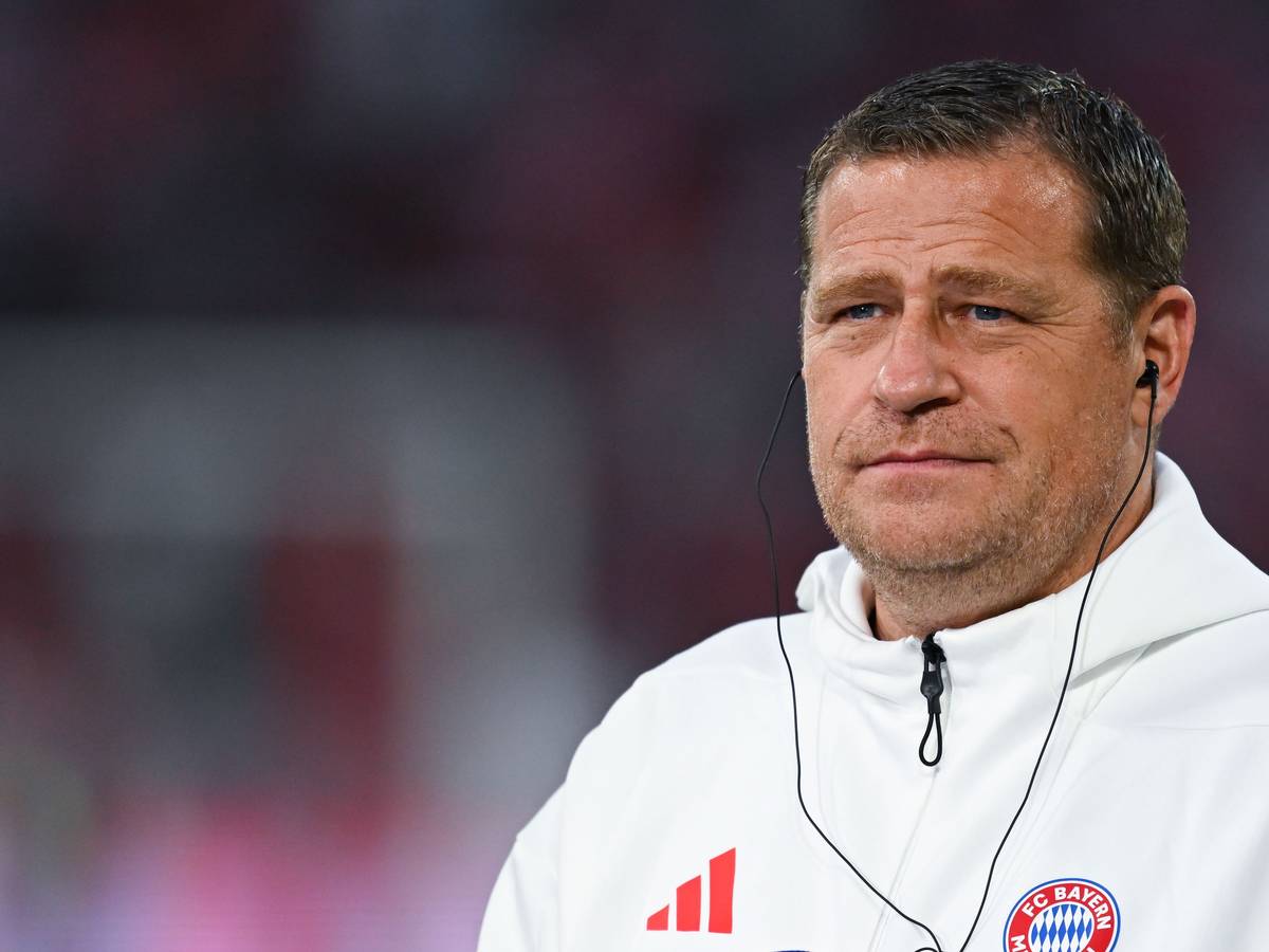 Max Eberl trägt bei einem Interview Kopfhörer im Ohr.