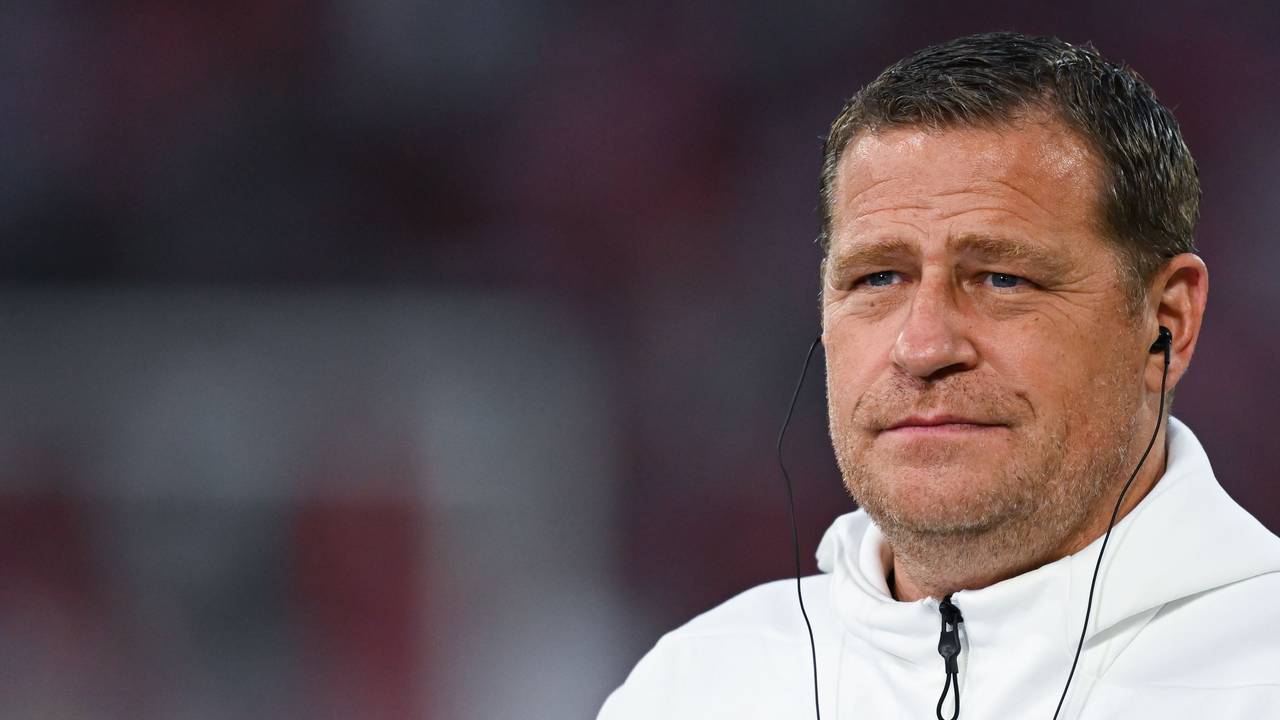 Max Eberl trägt bei einem Interview Kopfhörer im Ohr.