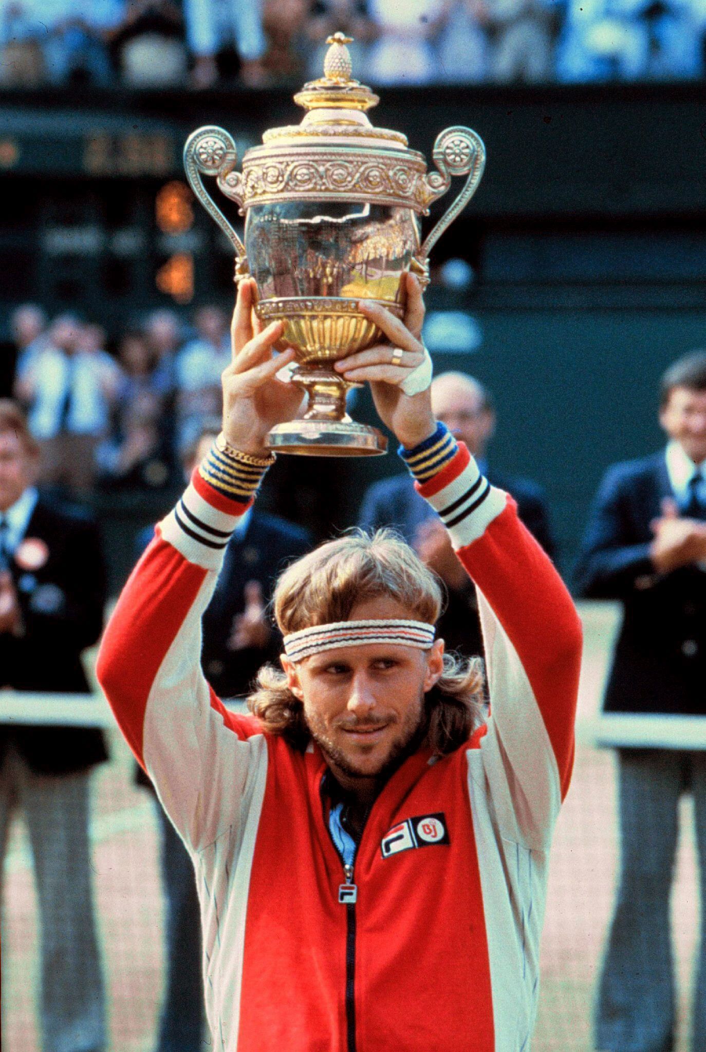 Björn Borg hält in Wimbledon einen Pokal in die Luft.