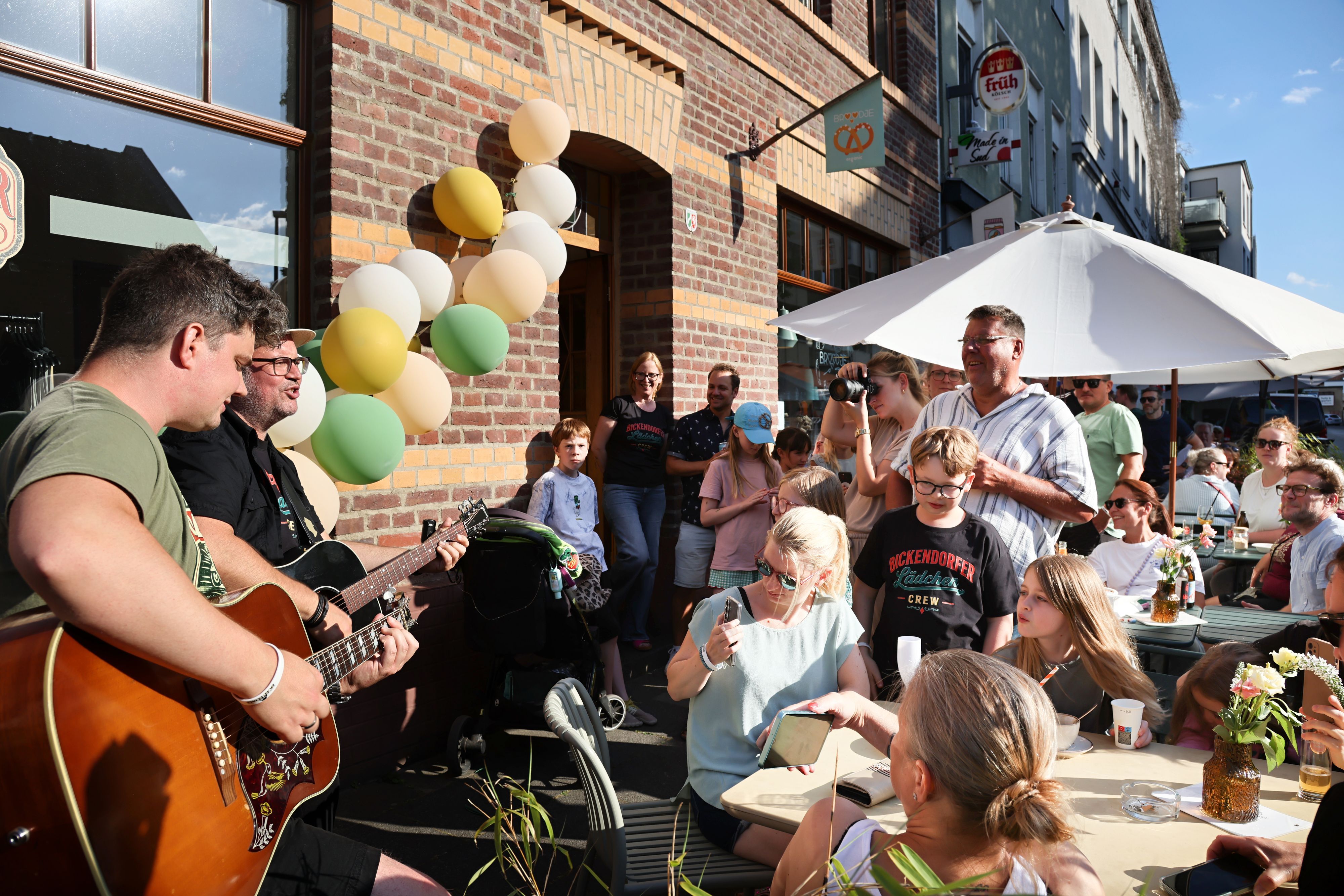 Björn Heuser singt mit Dennis Kleimann vor seinem Lädchen.