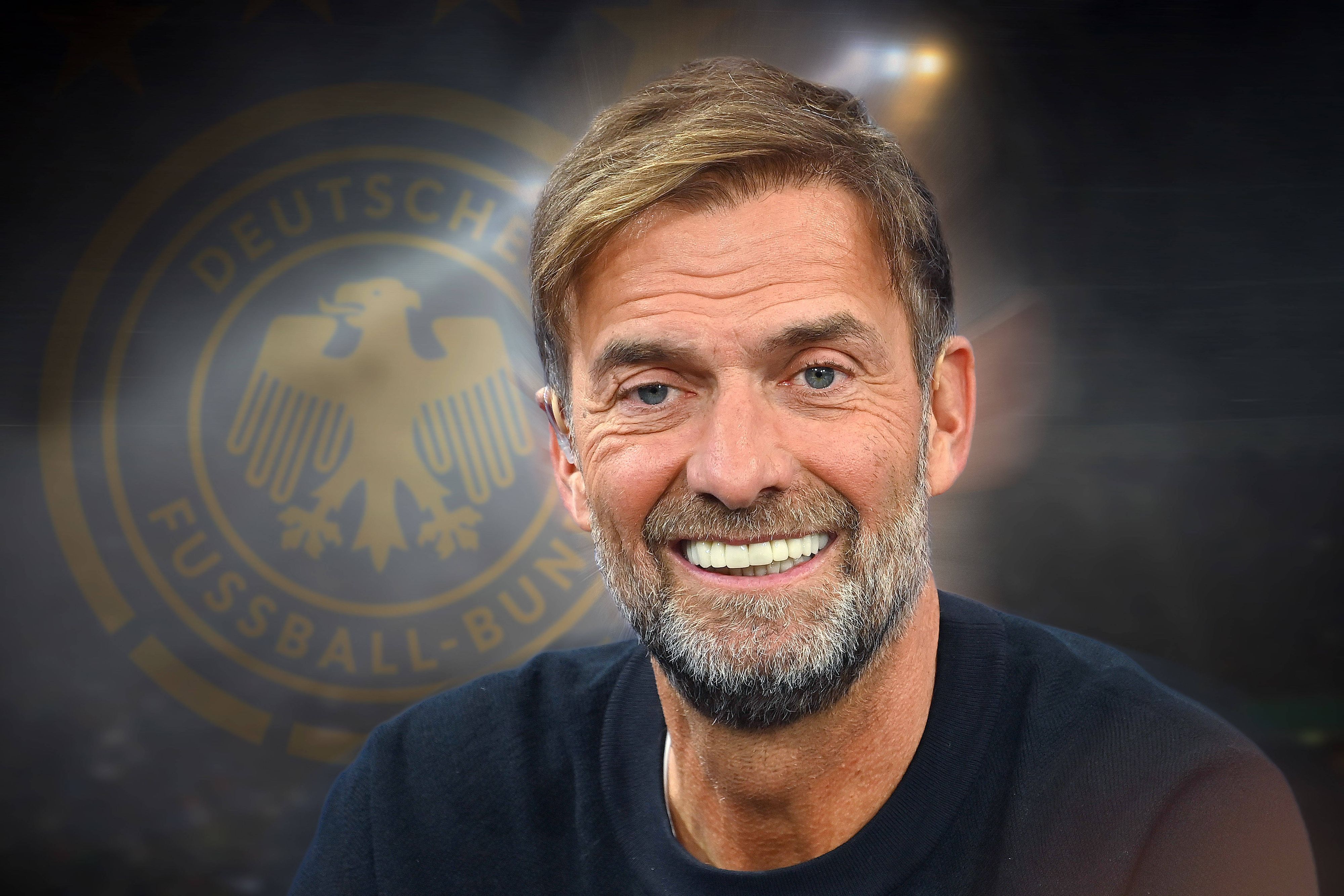 Jürgen Klopp lächelnd vor dem DFB-Logo im Hintergrund.