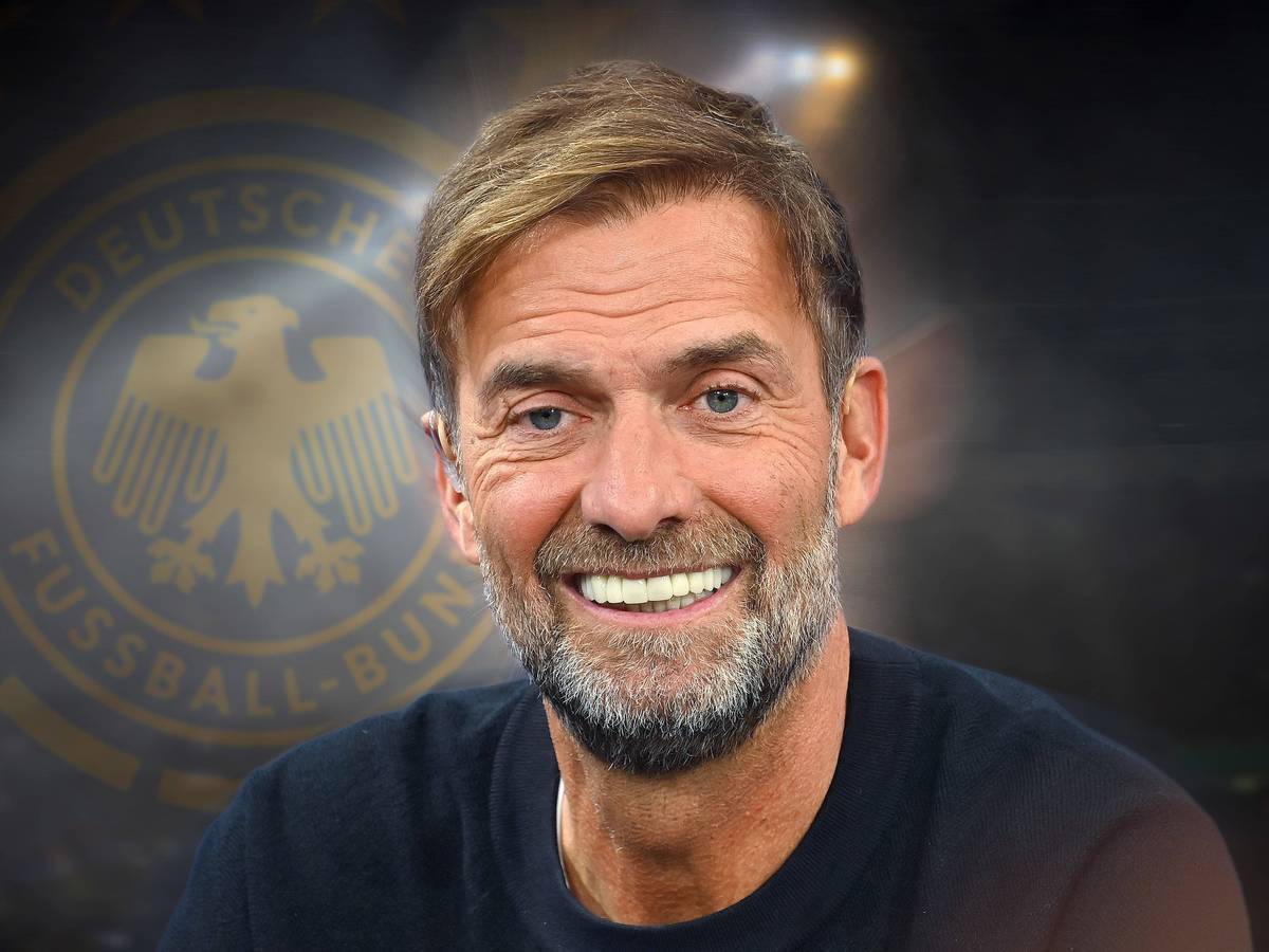 Jürgen Klopp lächelnd vor dem DFB-Logo im Hintergrund.