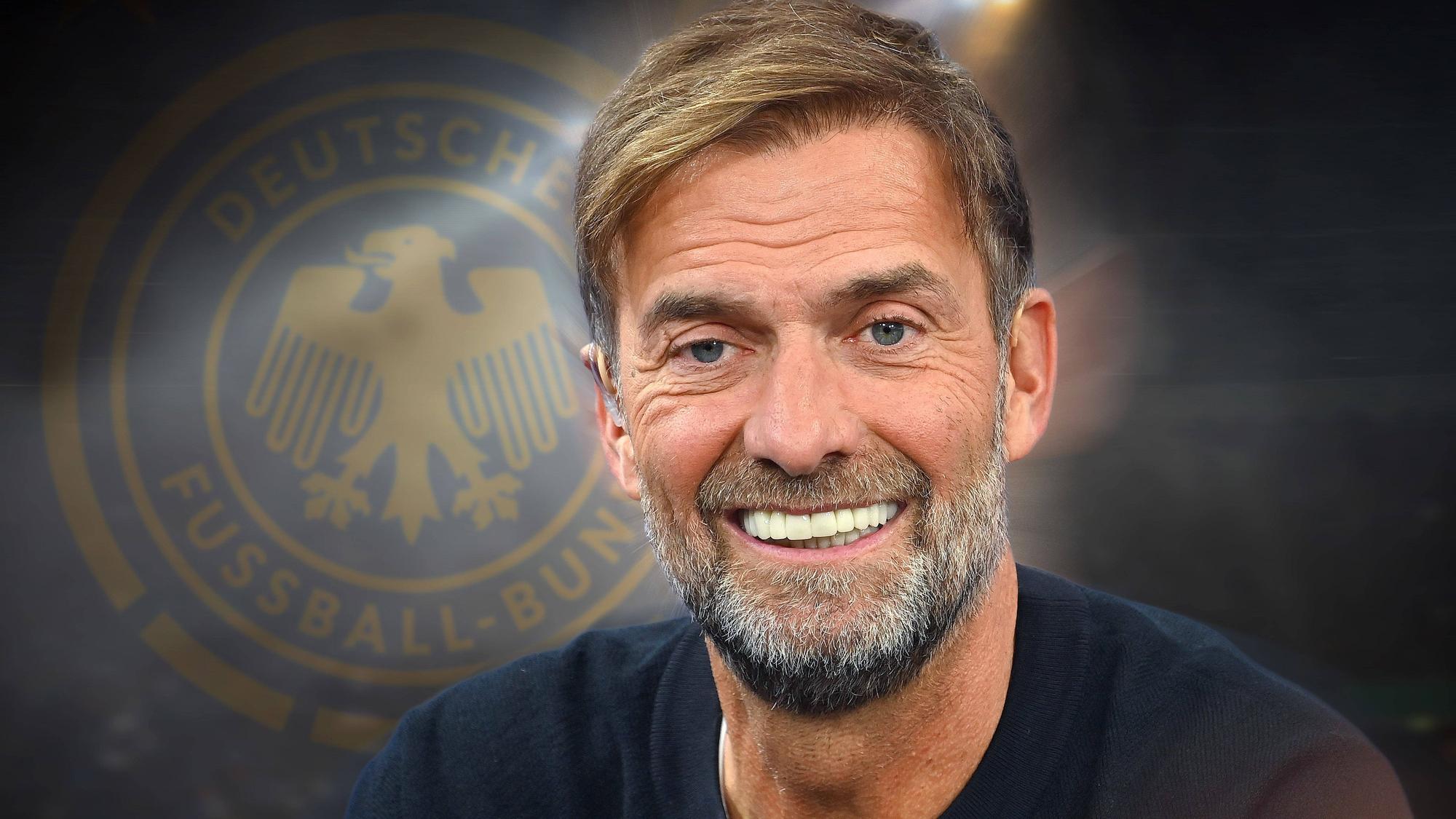 Jürgen Klopp lächelnd vor dem DFB-Logo im Hintergrund.