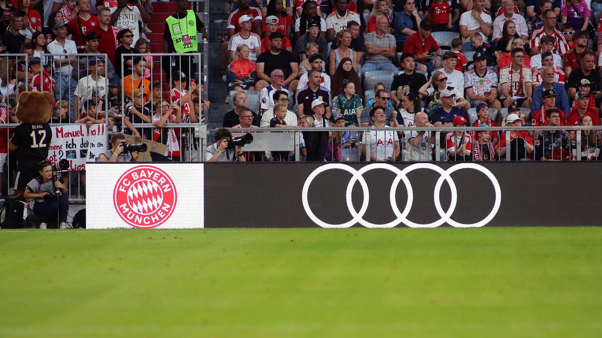 Eine Werbebande in der Allianz-Arena zeigt das Logo des FC Bayern neben dem Audi-Logo.