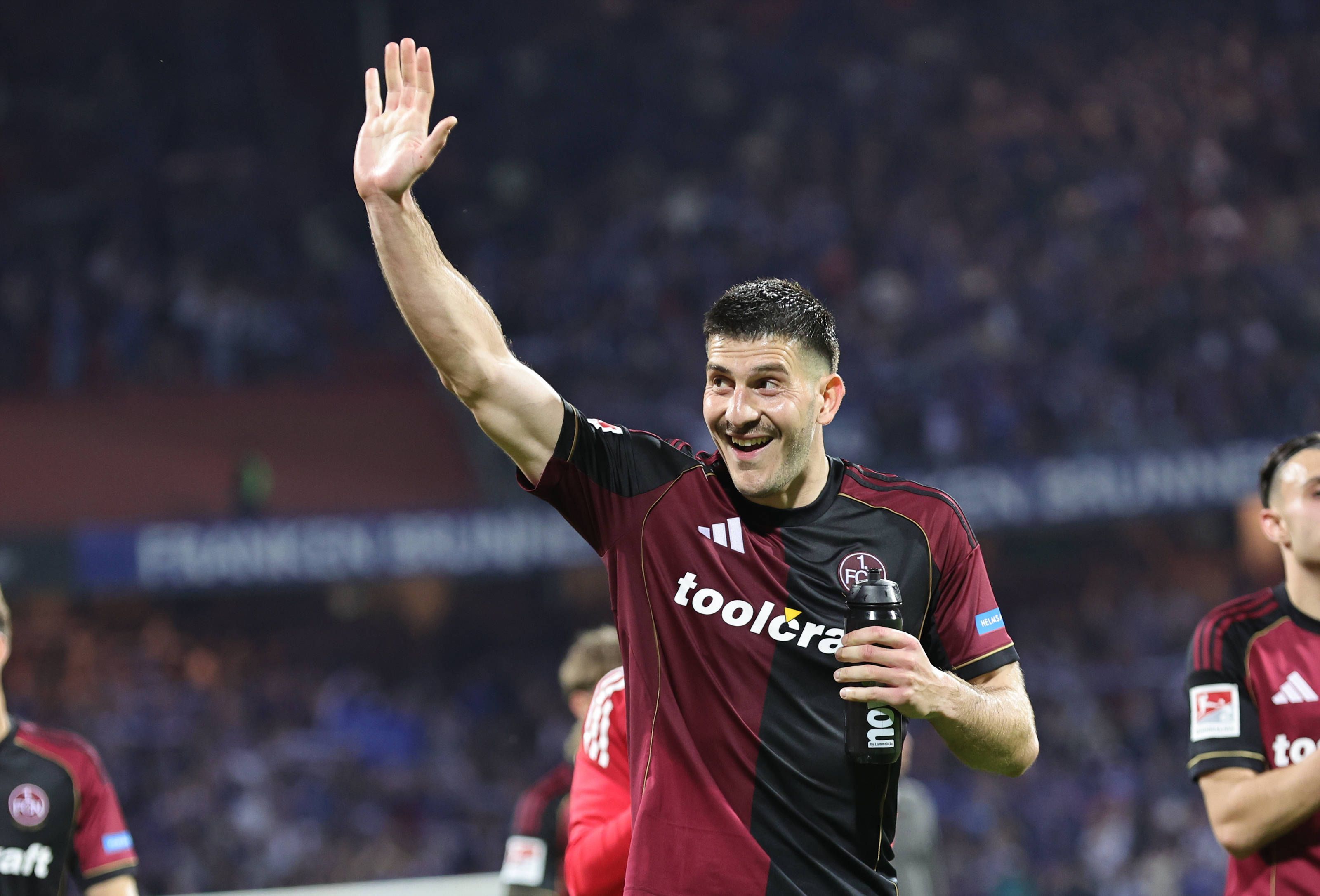 Luka Lochoshvili lacht und winkt auf die Tribüne.