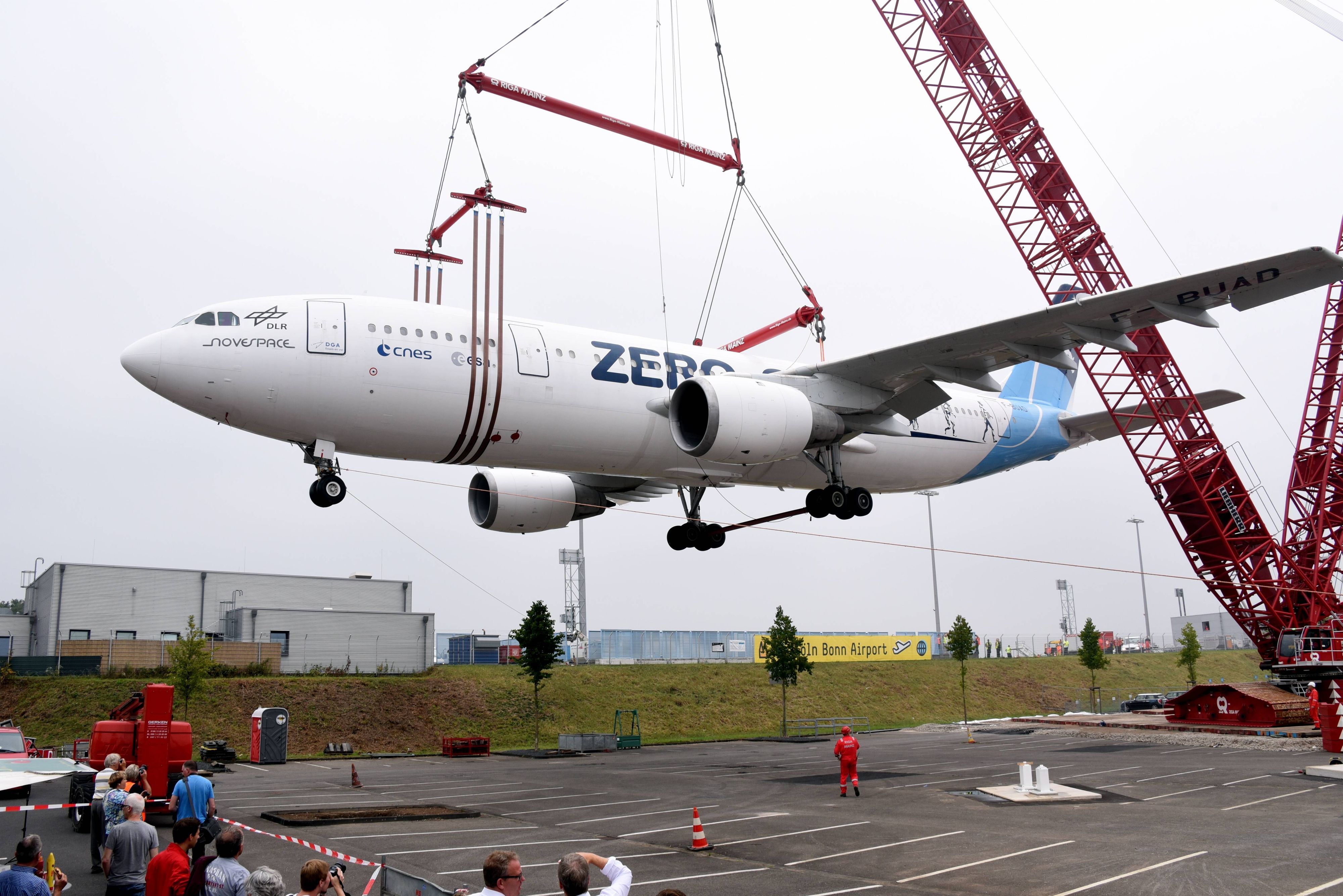 Der Zero-Airbus wird am 8. August 2015 am Flughafen Köln/Bonn mit einem 60 Meter hohen Schwerlastkran auf einen Parkplatz gehoben. Der Airbus A300  wurde vom Deutschen Zentrum für Luft- und Raumfahrt (DLR) bis 2014 als Parabelflugzeug benutzt.