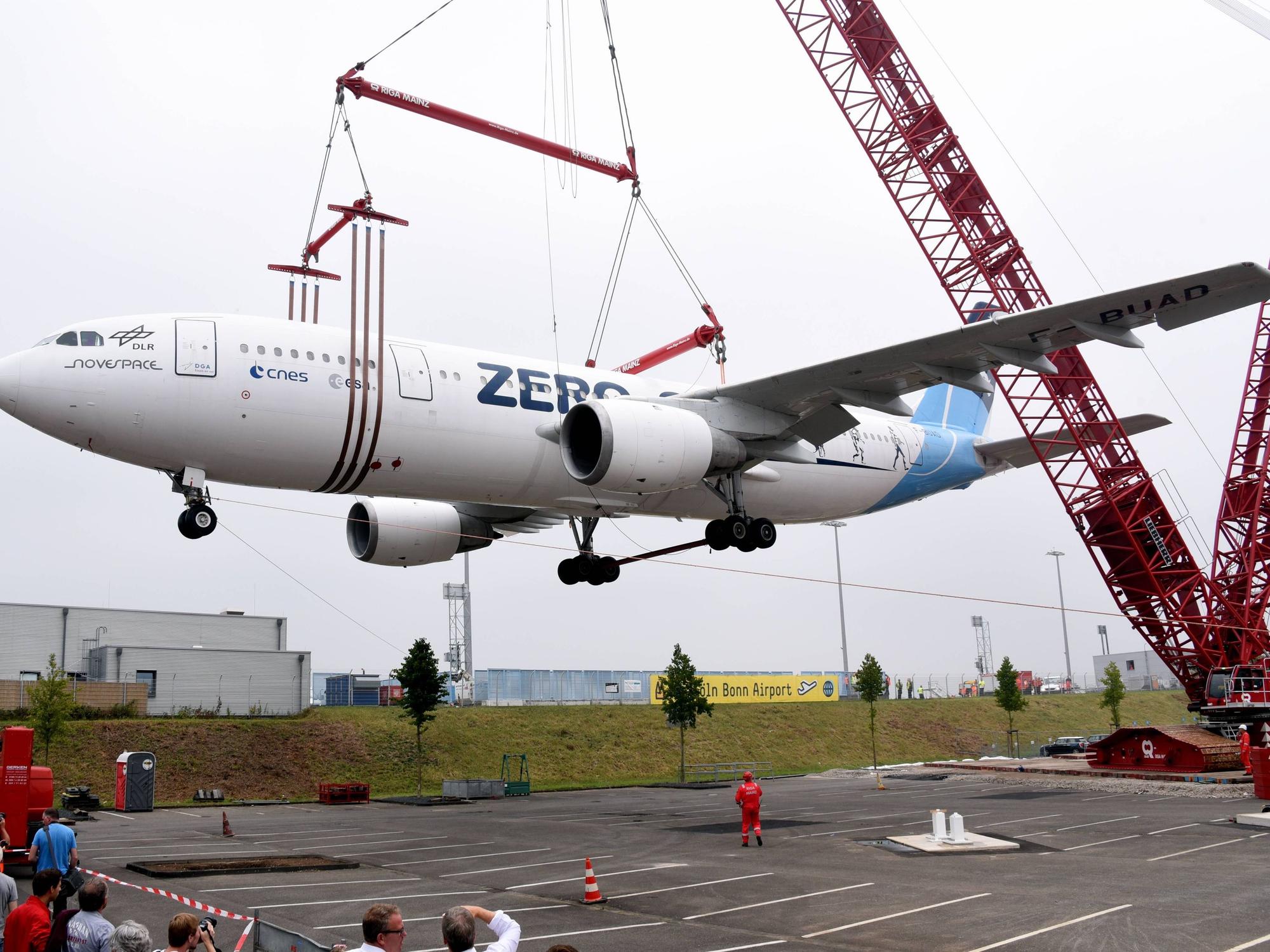 Der Zero-Airbus wird am 8. August 2015 am Flughafen Köln/Bonn mit einem 60 Meter hohen Schwerlastkran auf einen Parkplatz gehoben. Der Airbus A300 wurde vom Deutschen Zentrum für Luft- und Raumfahrt (DLR) bis 2014 als Parabelflugzeug benutzt.