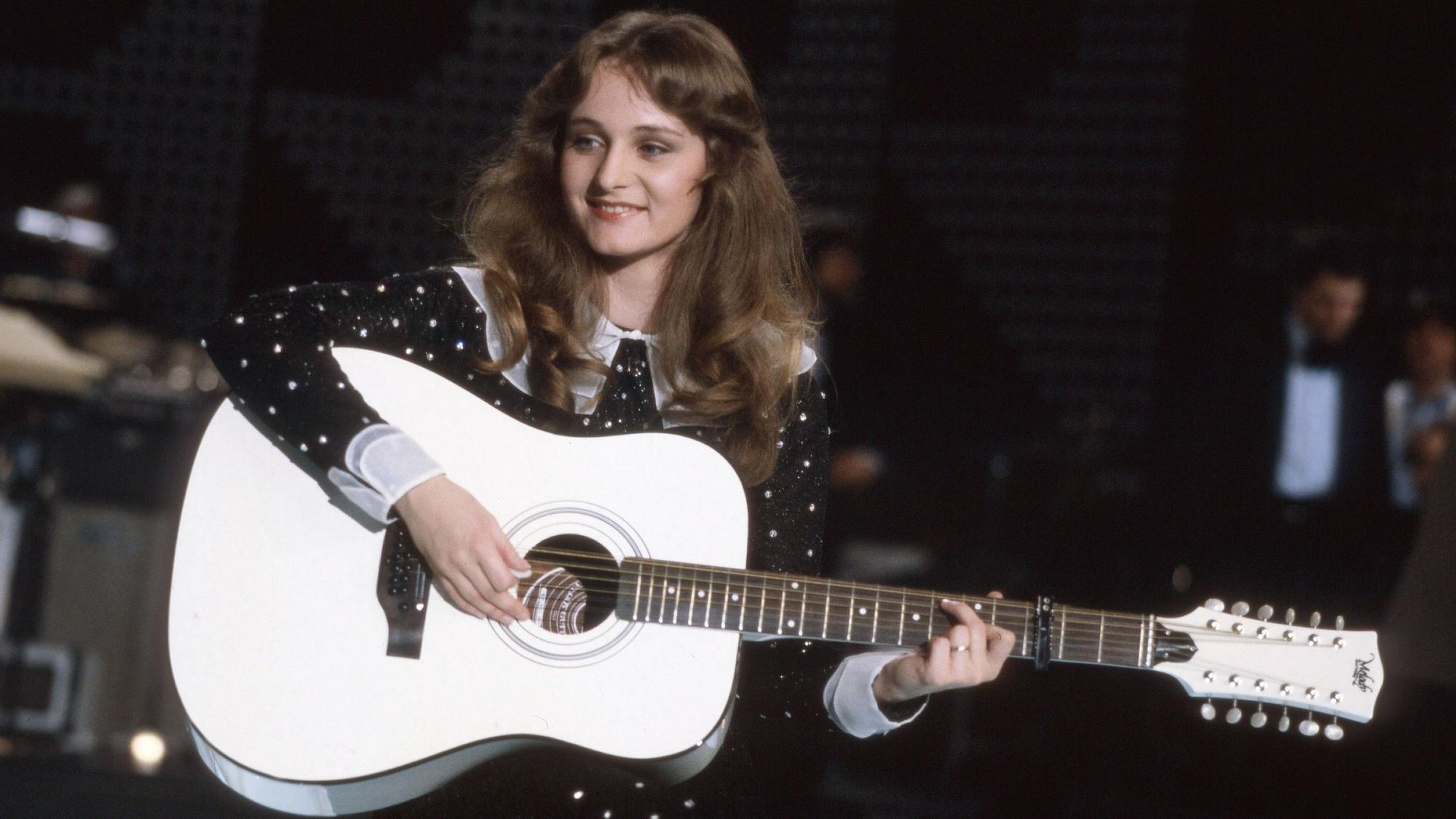 Eine junge Frau mit langen Haare und einer Gitarre