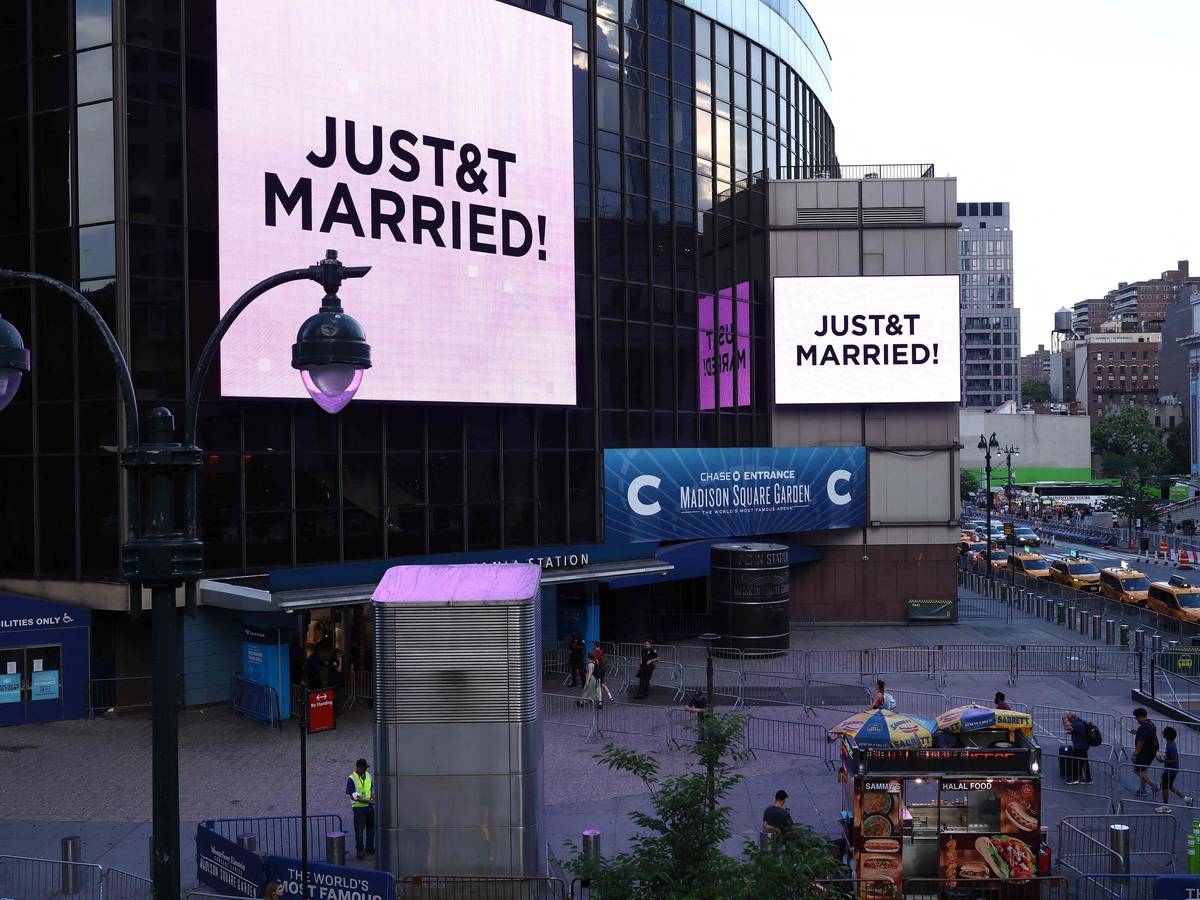 Vor dem Madison Square Garden, dem angeblichen Veranstaltungsort für die Hochzeitsfeierlichkeiten der Popsängerin Taylor Swift und des Profisportlers Travis Kelce, sind riesige Bildschirme zu sehen, auf denen die Botschaft „JUST&T MARRIED!“ (T&T steht für Taylor und Travis) zu lesen ist.