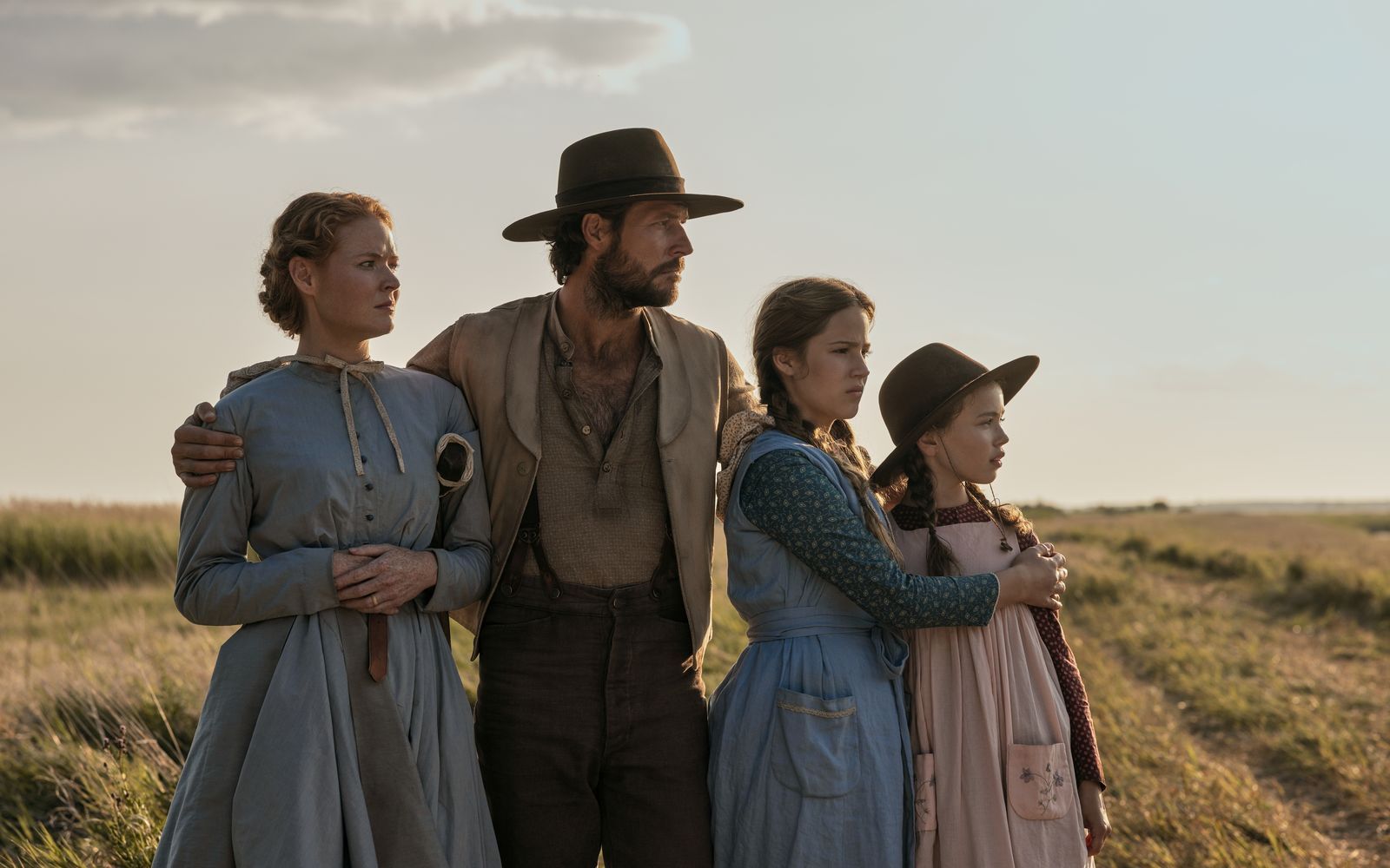 Familienvater Charles Ingalls (Luke Bracey) hat mit seiner Frau Caroline (Crosby Fitzgerald, links) und den Töchtern Mary (Skywalker Hughes, zweite von rechts) und Laura (Alice Halsey) ihre Heimat in Wisconsin verlassen, um in fruchtbarerem Land, das von der Regierung als frei versprochen wurde, ein neues Leben zu beginnen. (Bild: Eric Zachanowich/Netflix © 2026)