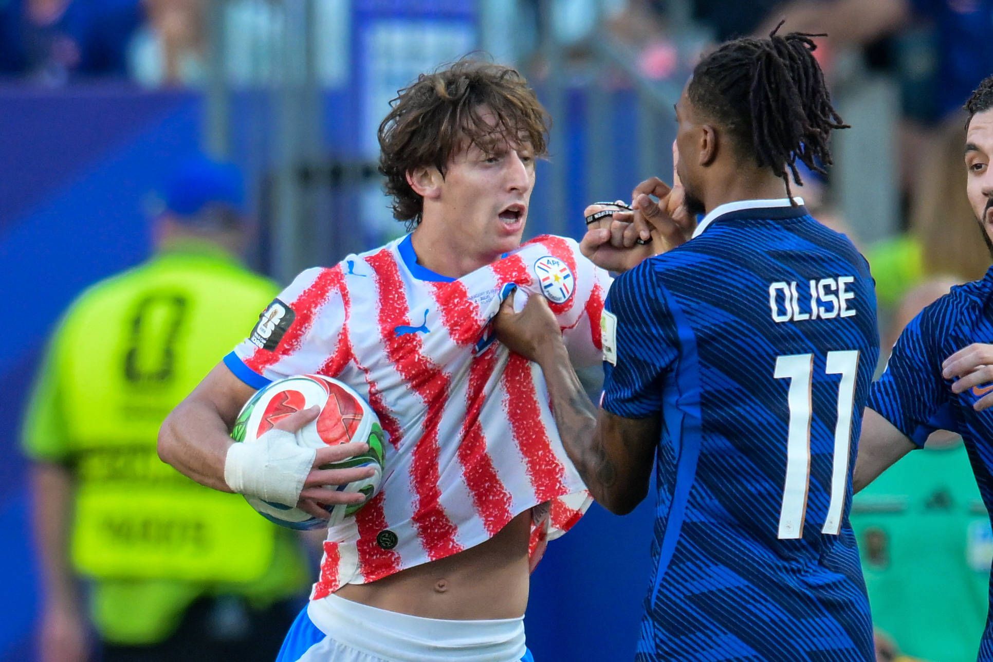 Michael Olise zeigt Matías Galarza mit dem Zeigefinger auf dem Mund an, still zu sein.