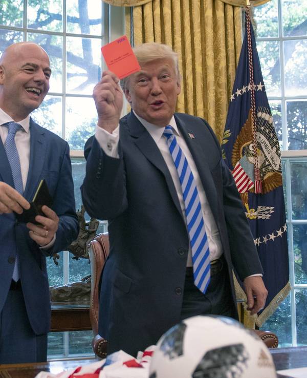 US-Präsident Donald Trump hält im Oval Office eine Rote Karte in die Kamera, FIFA-Präsident Gianni Infantino lacht.