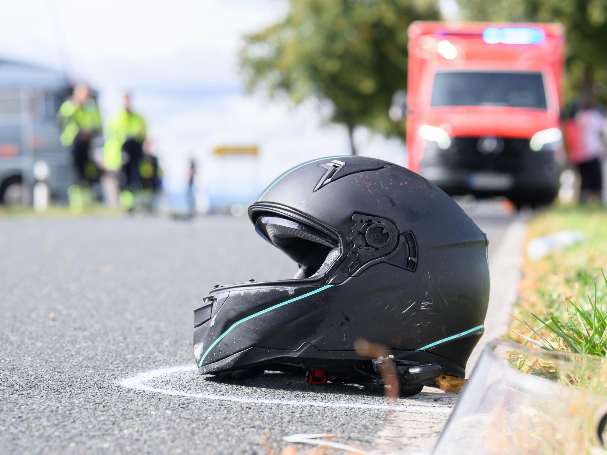 Ein Motorradhelm liegt nach einem Unfall am Rand einer Straße.