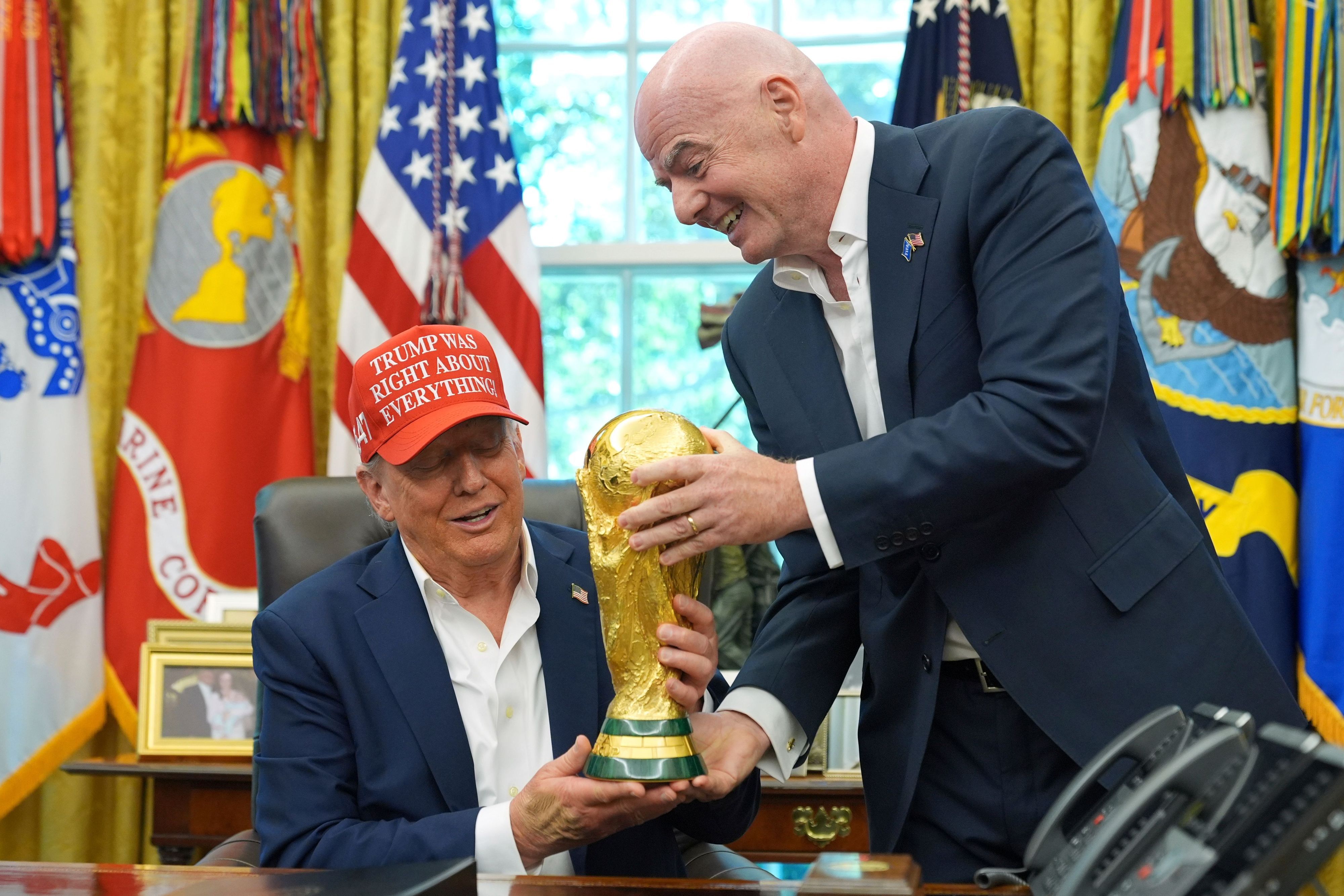 FIFA-Präsident Gianni Infantino (r) überreicht US-Präsident Donald Trump die FIFA World Cup Winners Trophy bei einer Ankündigung im Oval Office des Weißen Hauses.
