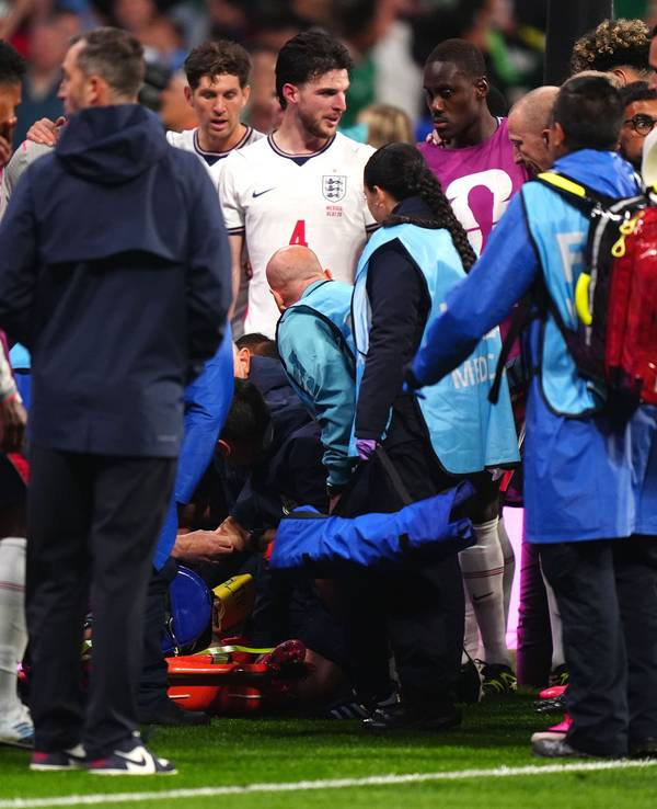 Spieler und medizinische Betreuer stehen um ihren Mitspieler Jordan Henderson (verdeckt).