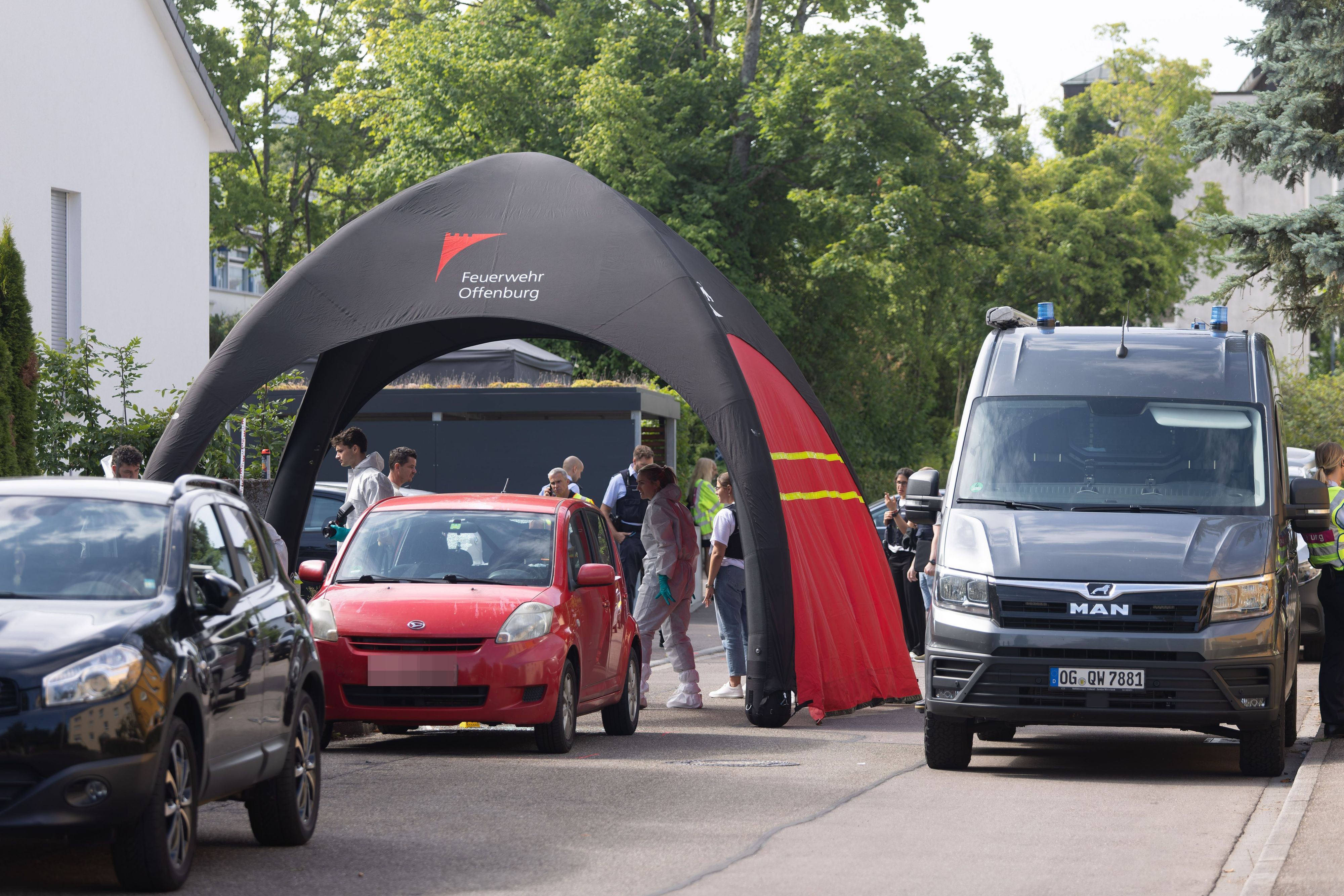Beamte der Kriminalpolizei und der Kriminaltechnik stehen an dem Tatort in Offenburg.