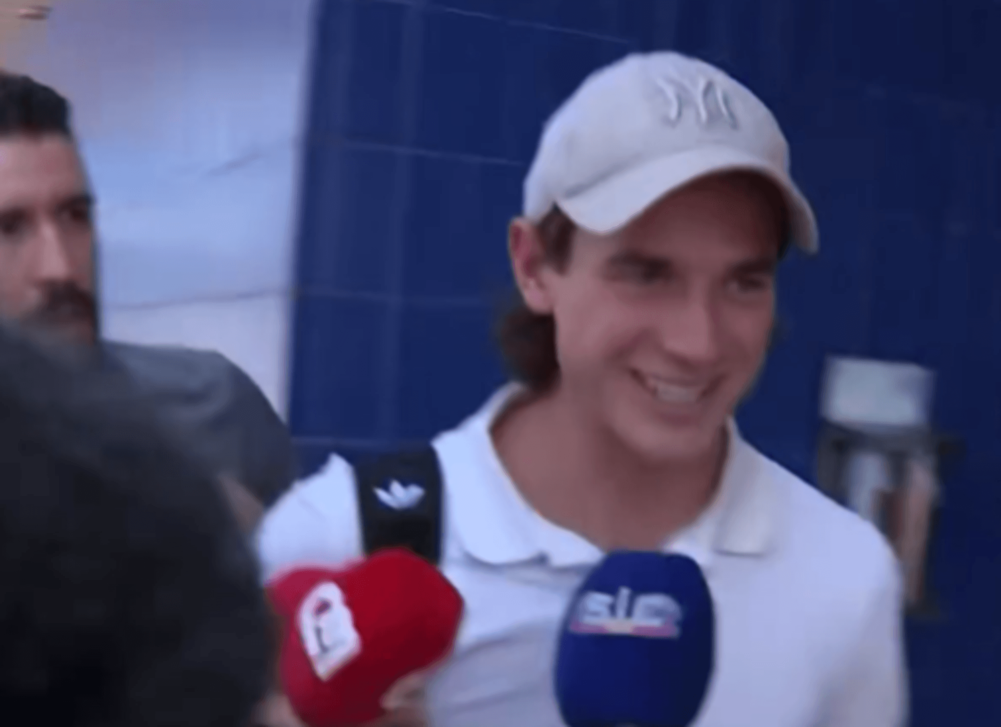 Jakub Kaminski werden Mikrofone vor das Gesicht gehalten.