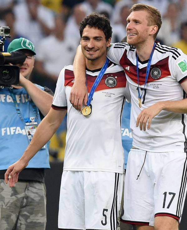 Mats Hummels und Per Mertesacker gehen nach dem Gewinn der WM 2014 Arm in Arm über den Platz.
