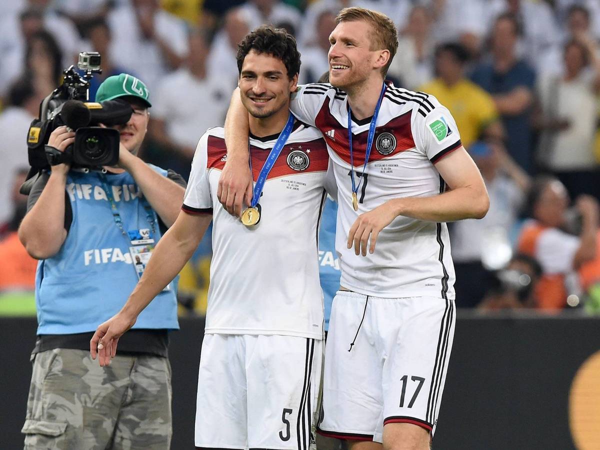 Mats Hummels und Per Mertesacker gehen nach dem Gewinn der WM 2014 Arm in Arm über den Platz.