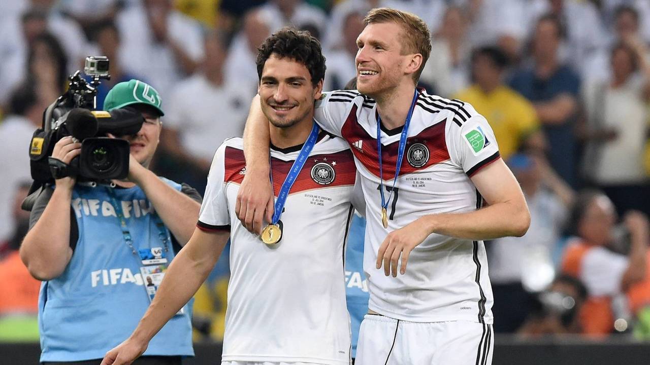 Mats Hummels und Per Mertesacker gehen nach dem Gewinn der WM 2014 Arm in Arm über den Platz.