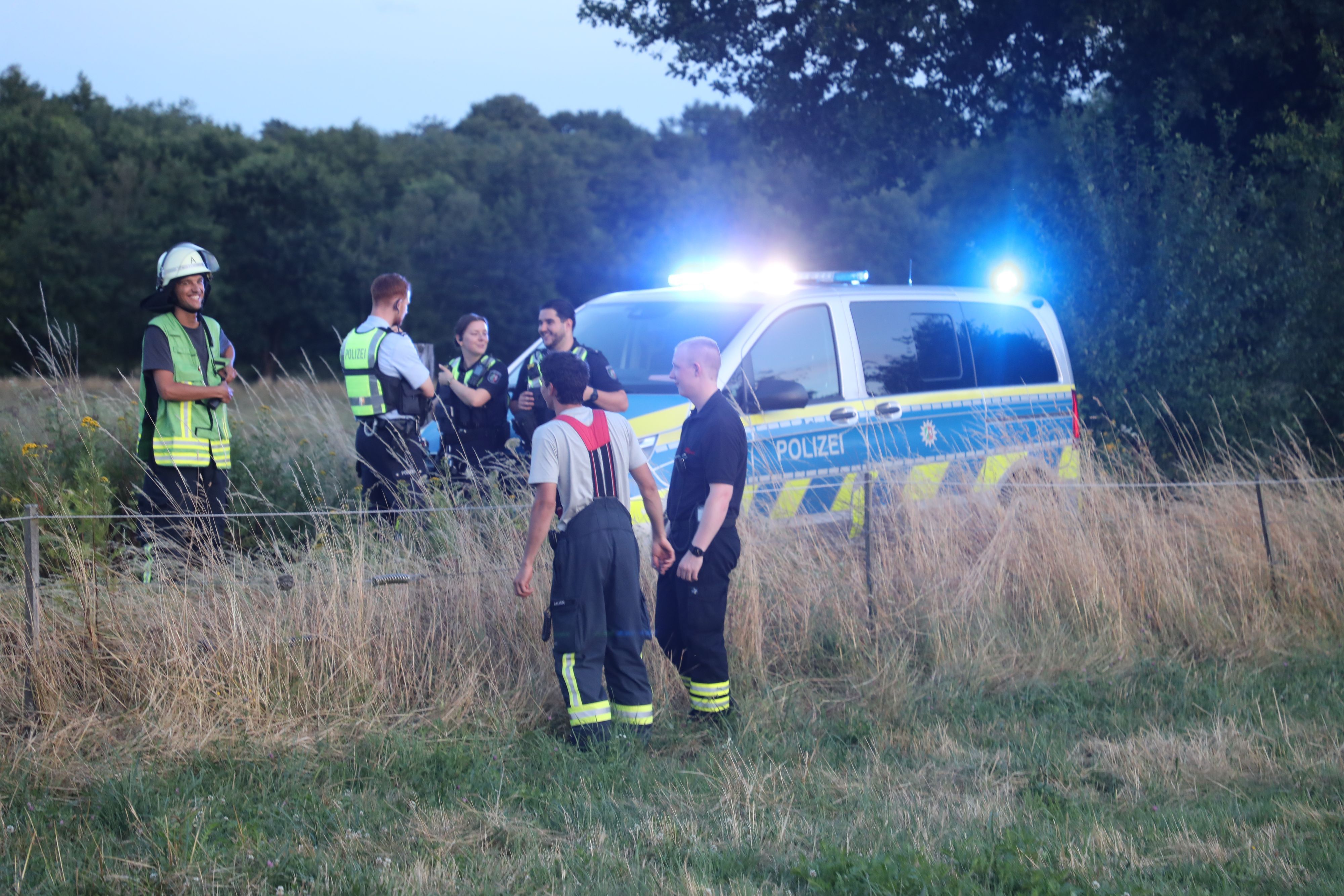 Polizei und Feuerwehr stehen auf einem Weg in der Wahner Heide.