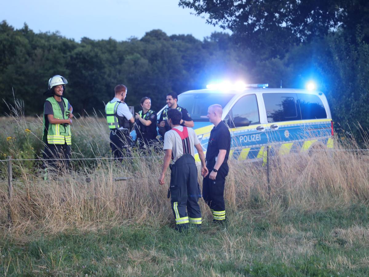 Polizei und Feuerwehr stehen auf einem Weg in der Wahner Heide.