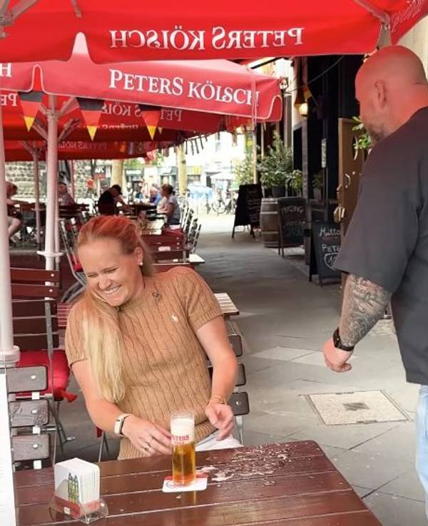 Ein Köbes und eine Kundin in einem Brauhaus in Köln