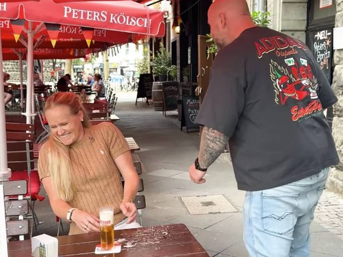 Ein Köbes und eine Kundin in einem Brauhaus in Köln